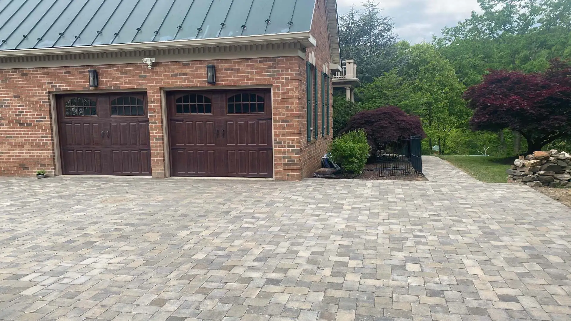 Custom stone paver driveway installed beside garage openings in Rappahannock County, VA.