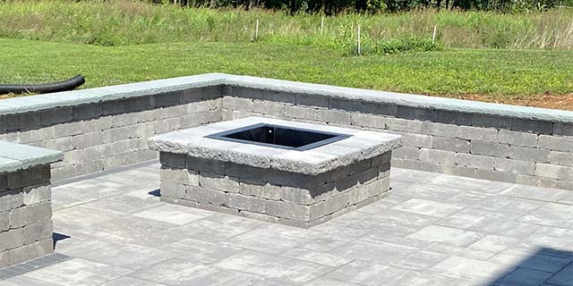Custom fire pit installed with seating walls and a patio in Haymarket, VA.