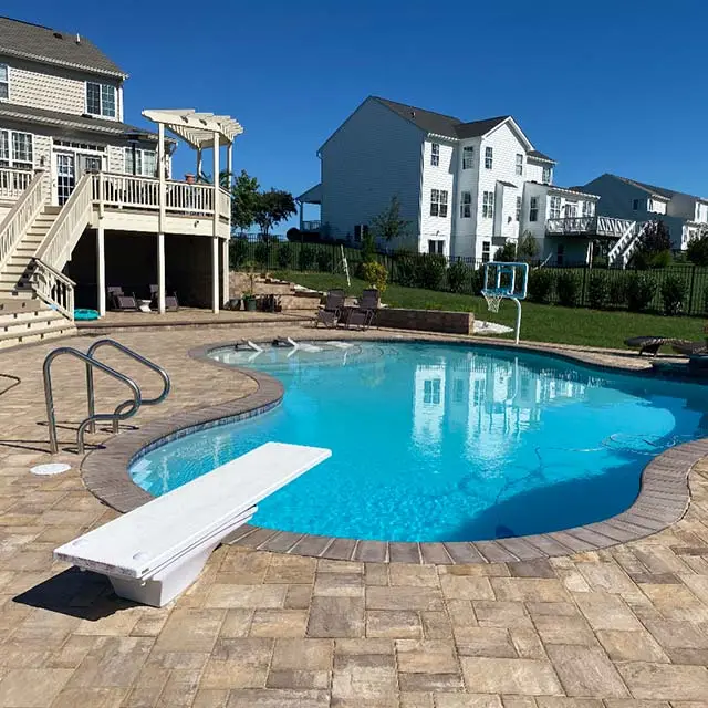Large patio with a swimming pool and diving board in Purcellville, VA.