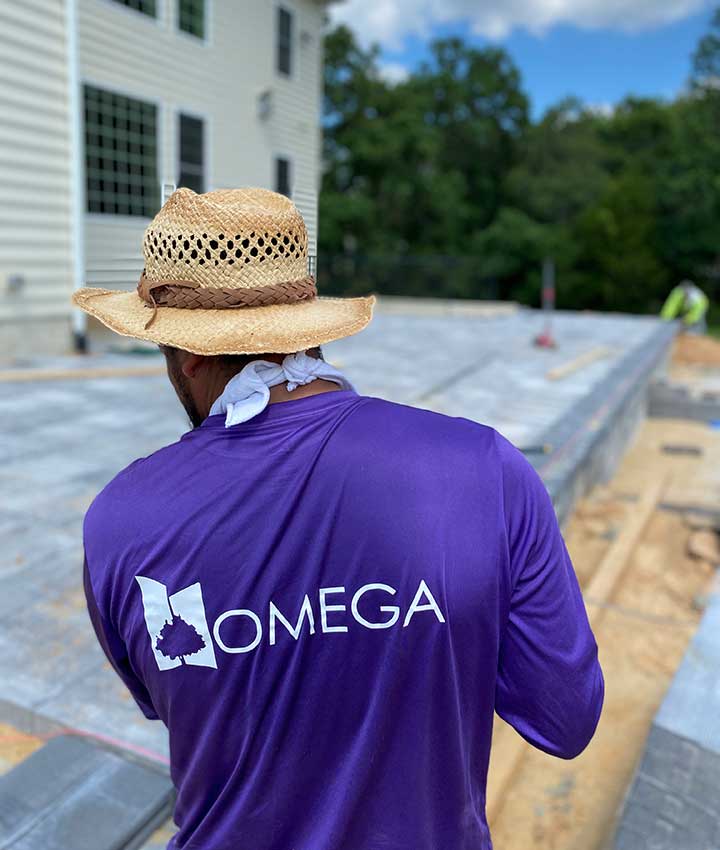 Omega Landscape Construction worker in Middleburg, VA overseeing a patio installation.